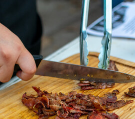 tocino.

tiras de tocino en el asador. 

cortando tocino en cuadritos sobre tabla de madera.