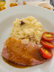 photo of a plate with rice, steak and tomatoes