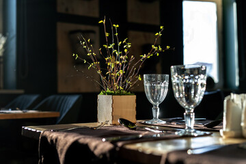 The interiors of the restaurant are in rustic style, a beautiful sunbeam shines on the glasses. Side view