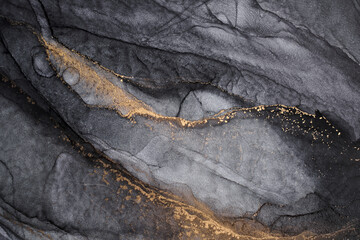 Luxury abstract dark background in alcohol ink technique, black gold liquid painting, scattered acrylic blobs and swirling stains, printed materials