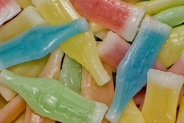 Wax Bottles candy background scattered with assorted colors and flavors. Directly above flat lay...