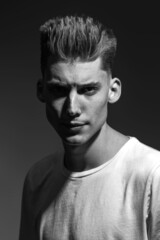 Male beauty concept. Portrait of a fashionable young man with stylish haircut. Close up. Copy-space black and white image