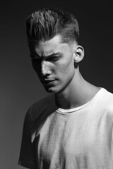 Male beauty concept. Portrait of a fashionable young man with stylish haircut. Close up. Copy-space black and white image