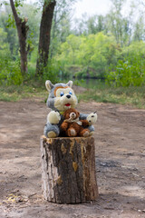 toys dog and bear sit on a stump
