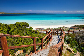 Beautiful view of Pelosa Beach (Spiaggia Della Pelosa). Stintino. La Pelosa beach, probably the most beautiful beach in Sardinia, Italy. Popular travel destination. Wooden bridge.