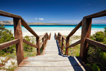 Beautiful view of Pelosa Beach (Spiaggia Della Pelosa). Stintino. La Pelosa beach, probably the most beautiful beach in Sardinia, Italy. Popular travel destination. Wooden bridge.