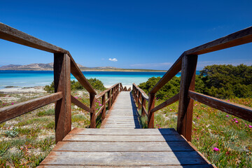 Fototapeta premium Beautiful view of Pelosa Beach (Spiaggia Della Pelosa). Stintino. La Pelosa beach, probably the most beautiful beach in Sardinia, Italy. Popular travel destination. Wooden bridge.