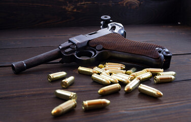 Historic Luger P08 Parabellum handgun, old soviet TT handgun and shiny 9 mm bullets on wooden...