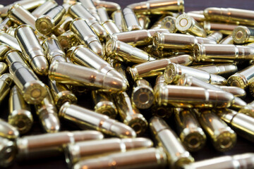 Golden pistol bullets on a wooden background, no war and invasion concept
