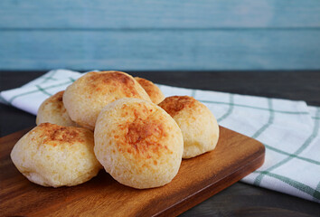 Heap of Delectable Brazilian Cheese Breads Called Pao de Queijo on Wooden Breadboard