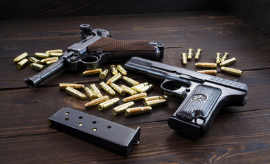 Historic Luger P08 Parabellum handgun, old soviet TT handgun and shiny 9 mm bullets on wooden...