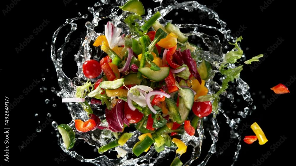 Aufkleber Super slow motion of rotating fresh lettuce flying up in the air. Splashing water. Isolated on black background. Filmed on high speed cinema camera, 1000 fps.