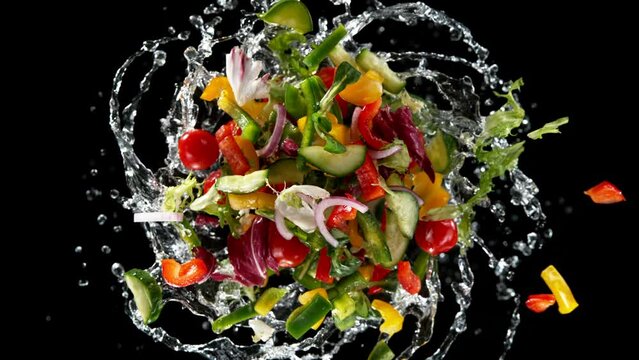 Super slow motion of rotating fresh lettuce flying up in the air. Splashing water. Isolated on black background. Filmed on high speed cinema camera, 1000 fps.