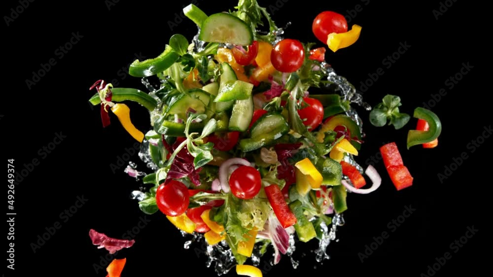 Poster super slow motion of rotating fresh lettuce flying up in the air. splashing water. isolated on black