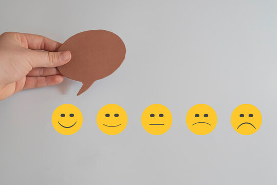 Hand holding speech bubble on eva paper cut. User online, service experience. Customer review satisfaction feedback survey concept