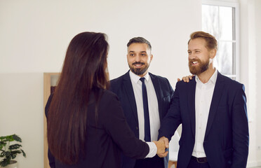 Diverse smiling businesspeople shake hands get acquainted greeting at business negotiations. Happy partners or colleagues handshake close deal or make agreement. Partnership concept.