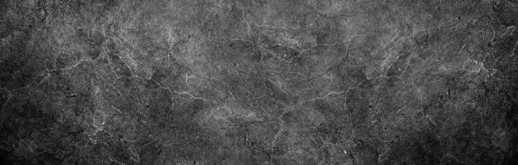 Dark black gray industrial background grunge stained marbled stone wall or rock surface texture with gritty grunge pattern and dark border in abstract black white website banner header backdrop design