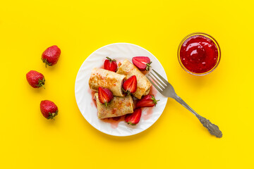 Sweet breakfast - rolled pancakes with strawberry and berry sauce