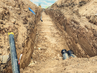 construction of a new neighborhood. digging a ditch for laying sewer pipes. sewerage system in...