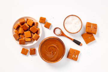 Bowl of caramel sauce and toffee candies with sea salt, top view