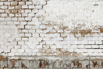 Cracked damaged old white brick wall as background and urban texture
