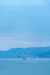 Fisherman and fishing boat in Adriatic sea in early morning