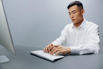 worker in a white shirt works at a computer in the office isolated background