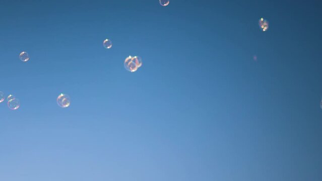 shiny soap bubbles floating in the air under the blue sky. happy childhood, summer entertainment