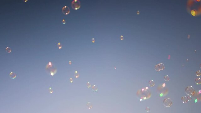 shiny soap bubbles floating in the air under the blue sky. happy childhood, summer entertainment