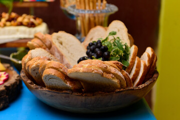 basket with sliced ​​italian breads and purple grapes, baker's day, breakfast buffet