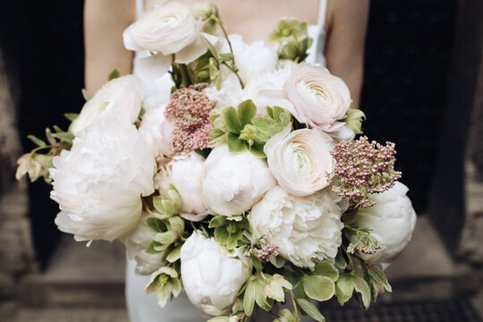 Beautiful wedding bouquet of roses in the hands of the bride
