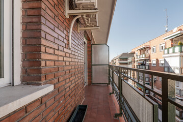 Vacation apartment terrace with clay floors and brown bricks overlooking an urban street