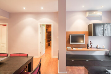 Dining room of vacation rental apartment with dark wood furniture with mirror, decor, air conditioning, plasma tv and sideboard and lilac painted walls