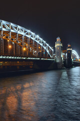 Obraz premium the beautiful metal bridge of Peter the Great across the Neva River in St. Petersburg against the night sky