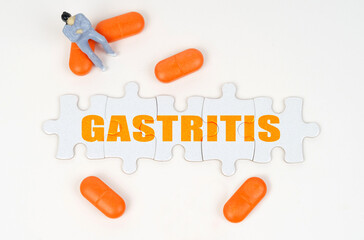 On the white surface of the tablet, a miniature human figure and puzzles with the inscription - GASTRITIS