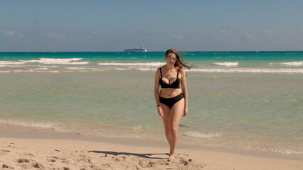 Young pretty woman wearing a bikini at Miami Beach on a windy day