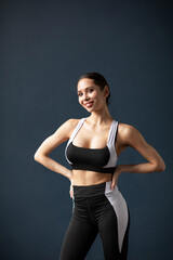 Fototapeta na wymiar Portrait of a beautiful smiling fitness woman in black and white sportswear