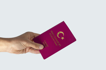 Turkish passport, hand holding a Turkish passport isolated on white