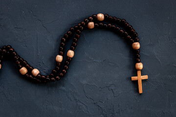 Wooden rosary beads with cross, top view. Christian concept