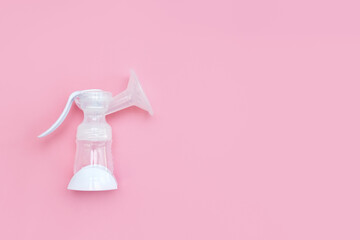Breast pump on a pink background. Breastfeeding concept. Copy space