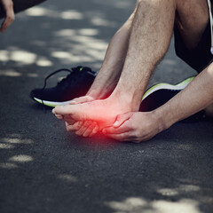 No pain, no gain. Cropped shot of an unrecognizable man suffering with foot cramp during a run.