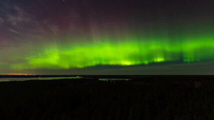 Aurora borealis, The Northern lights at the lake Usma and forest, Latvia. Aerial view.