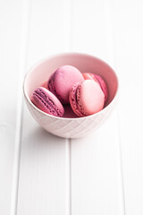 Sweet pink macarons. Traditional french macaroons. Tasty dessert in bowl.