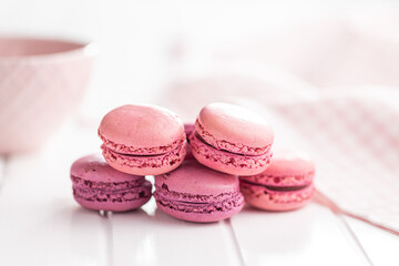 Sweet pink macarons. Traditional french macaroons. Tasty dessert on white table.