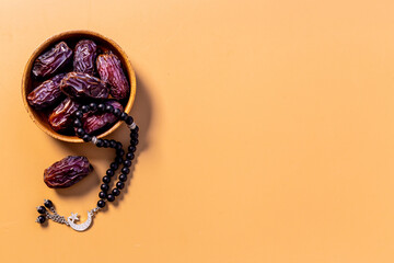 Fototapeta na wymiar Ramadan concept. Black islamic rosary with crescent with dates fruits