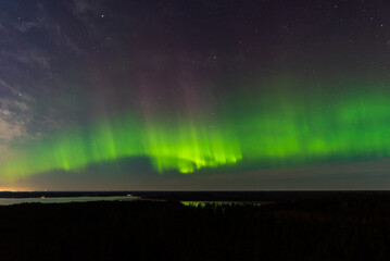 Aurora borealis, The Northern lights at the lake Usma and forest, Latvia. Aerial view.