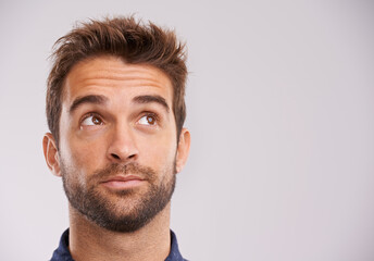 Handsome daydreamer. Studio shot of a handsome young man looking up.