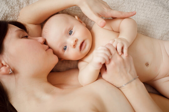 a naked mother and the baby on the bed. maternal and child health. 