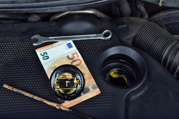  Europe euro money currency and the thick, greasy yellow motor oil under oil cap