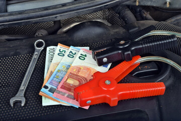 Europe euro money currency and ring spanner and electricity jumper cables to charging car battery